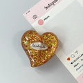 Vista macro del supporto per telefono a cuore glitterato con incisione artigianale - Stile 15