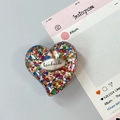 Dettaglio del supporto per telefono a cuore con paillettes colorate e marchio fatto a mano - Stile 5