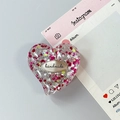 Dettaglio del supporto per telefono a cuore in resina con glitter a stelle e tag - Stile 7
