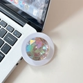Iridescent faceted gem phone grip holder displayed next to a laptop keyboard on desk - Iridescent