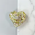 Macro del supporto per telefono a cuore glitterato con testo fatto a mano su scrivania - Stile 10