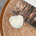 Dettaglio del supporto per telefono a cuore con testo Gift For You su tavolo in legno - Specchio a Cuore Magnetico - Consistenza della Carta Stagnola