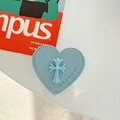 Detail der hellblauen herzförmigen Leder-Handyhalterung mit geprägtem Kreuz und Text - Klebender Ständer - Blau
