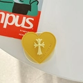 Dettaglio del supporto per telefono a cuore in pelle gialla con croce e scritta - Supporto Magnetico - Giallo