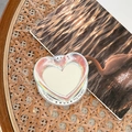 Dettaglio del supporto per telefono a cuore laser con stampa Gift For You su un libro - Specchio a Cuore Magnetico - Luce Blu