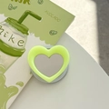 Detail of heart-shaped magnetic phone grip with vanity mirror in lime green - Fluorescent Green