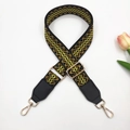 Detail of adjustable geometric jacquard bag strap with gold metal hooks and black leather ends - Gold Buckle / Black Base Yellow + Black Leather