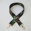 Macro shot of dark green nylon strap with colorful butterfly print and gold metal hooks - Butterfly Gold Buckle