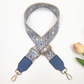 Dettaglio della tracolla ricamata geometrica con estremità in pelle e ganci in metallo oro - Base Beige Blu Lago