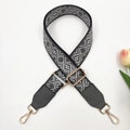 Close-up of geometric jacquard bag strap with grey leather ends and gold metal hooks - Black Dark Grey + Dark Grey Leather