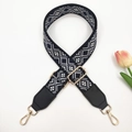 Detail of blue and white ethnic geometric embroidery on adjustable bag strap with gold hooks - Black Navy Blue + Black Leather