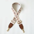 Macro detail of ethnic embroidered bag strap with floral patterns and golden hardware - Ethnic Embroidery (White/Brown)