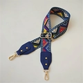 Close-up of ethnic geometric pattern woven strap with gold buckle and lobster clasp - Film Strip Blue Leather