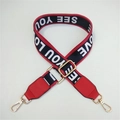 Close-up of red and black wide bag strap with SEE YOU LOVE text and golden metal hooks - Letter + Red Leather Trim