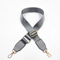 Detail of grey nylon shoulder strap with golden metal buckles and leather trim - Gray