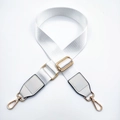 Close-up of adjustable white nylon strap with gold hardware and leather connectors - White