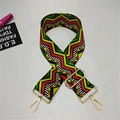 Close-up of colorful ethnic woven strap with zigzag patterns and gold metal lobster clasps - Wave
