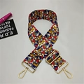 Detail of adjustable wide canvas shoulder strap with colorful geometric patterns and gold metal clips - Radiant