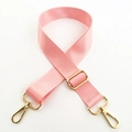Detail eines rosa Nylon-Schultergurts mit verstellbaren goldenen Metallschnallen - Silberverschluss / Rosa