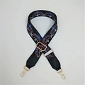 Close-up of adjustable ethnic peacock pattern bag strap with gold metal lobster clasps - Peacock