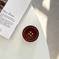 Detail view of the round wooden button style phone socket with vintage stitch patterns - Adhesive Grip Style / Black Tea