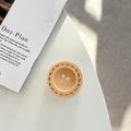 Detail of wooden button phone grip with light wood grain and needlework texture on white table - Adhesive Grip Style / Apricot