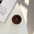 Macro detail of the dark brown wood texture and four-hole stitching on the button phone stand - Adhesive Grip Style / Coffee