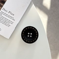 Top view of a black button-shaped magnetic phone grip with vintage industrial details - Adhesive Grip Style / Black
