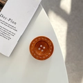 Detail of a brown wood-textured resin button phone stand with four holes and dot pattern - Adhesive Grip Style / Orange Coffee
