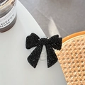 Close-up of elegant black rhinestone bow phone grip stand on a white table setting - Starry Resin Rhinestone Bowknot / Black / Adhesive