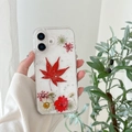 Macro shot of clear iPhone case with real pressed red maple leaf and white daisies - Floral Red (Real Flower) / iPhone 17 Pro Max