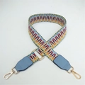 Macro detail of colorful geometric woven bag strap with blue leather and gold hooks - Light Weaving with Light Blue Leather