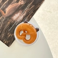 Nahaufnahme einer realistischen Brezel-Handyhalterung auf einer transparenten Basis - Laugenbrezel - Bär / Magnetisches Modell
