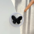 Detail eines funkelnden schwarzen Schmetterlings aus Strass auf einem weißen Sockel - Magnetic / Schwarz