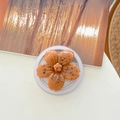 Gros plan d'un support de téléphone en forme de fleur de cerisier avec texture minérale - Fleur de Cerisier Effet Encre Magnétique - Orange
