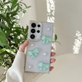 Details der glitzernden Hülle mit grünen Schleifen und Perlen für das Samsung S24 Ultra - Galvanisierter Rahmen – Glitzer-epoxidharz – Drei Kristallschleifen – Grün / Samsung A16