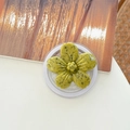 Detail of green flower phone grip with black speckles and transparent base on a desk - Magnetic Ink-wash Cherry Blossom - Dark Yellow