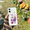 Clear iPhone case with purple dried flowers and silver glitter shown in an outdoor garden - iPhone 7/8/SE 2020 / Butterfly & Flower - Purple