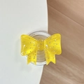 Detail der gelben Glitzer-Schleifen-Handyhalterung für MagSafe mit glänzendem Harz-Finish - Dunkelgelb