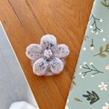 Primer plano de un soporte para móvil con forma de flor 3D lila sobre mesa de madera - Soporte Flor de Cerezo - Estilo Tinta - Rosa
