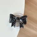 Makro-Detail einer 3D-Schleifen-Handyhalterung mit buntem Glitzer und Magnetbasis - Schwarz