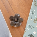 Detail view of a 3D caramel flower phone grip holder on a warm wooden background - Cherry Blossom Socket - Ink Style - Caramel