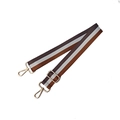 Close-up of a wide striped nylon bag strap with gold metal buckles and adjustable hardware - Brown-White-Grey
