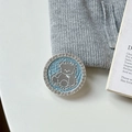 Close-up of a blue bear phone grip with rhinestones on a white background and grey fabric - Transparent Stand Style / Blue