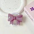 Macro detail of purple bow phone grip on ceramic tray with elegant aesthetic display - Mauve