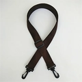 Macro detail of dark brown nylon strap with durable black plastic swivel hooks and buckle - Brown