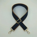 Close-up of adjustable navy blue woven bag strap with brown leather trim and gold hooks - Blue