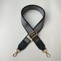 Close-up of adjustable chevron woven bag strap with golden metal hooks and leather detail - Silver Thread Black Leather