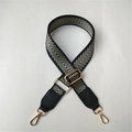 Close-up of adjustable wide shoulder strap with black and gold geometric V-pattern - Light Gold Thread Black Leather