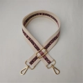 Macro shot of adjustable canvas strap with gold metal buckle and pink purple stripe - Off White